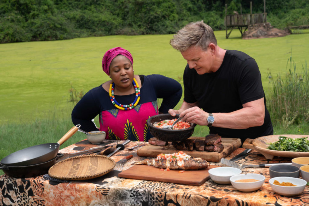 Zola Nene observes as Gordon Ramsay tops grilled fish with ushatini, a combination of onions and tomatoes.