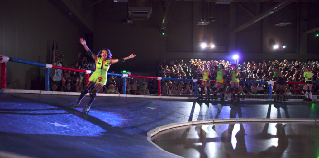 A competitor being introduced to the roller derby crowd in Home Game.
